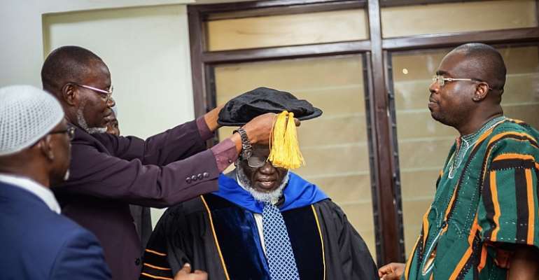 Dr. Rashid Hussain Salwat being honored. Looking on is Prof. Raphael Nyarkotey Obu in African wear