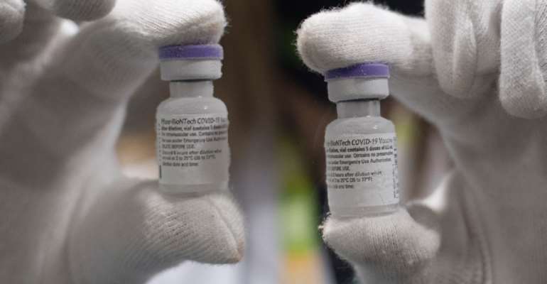 A laboratory technician holds a Pfizer-BioNTech Covid-19 vaccines at the Bidafarma wholesale distribution cooperative in Santa Fe, on the outskirts of near Granada, on January 21, 2021.  JORGE GUERRERO / AFP