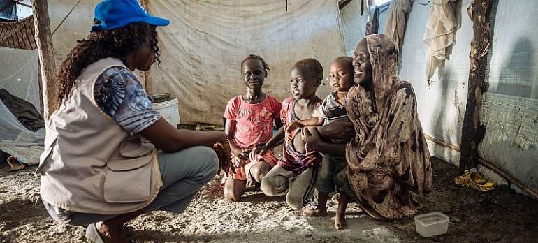 IOM/Muse Mohammed: An IOM staff member talks to a family in South Sudan