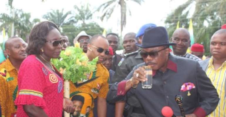 (L-R): Anambra State governor Chief Willie Obiano takes a sip of water from the borehole commissioning at Agbiligba Nanka, Orumba North LGA