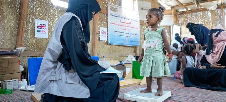 UNICEF/Mohanad Waqqas: An 18-month-old girl suffering from malnutrition is weighed at a displaced camp in Lahj, Yemen
