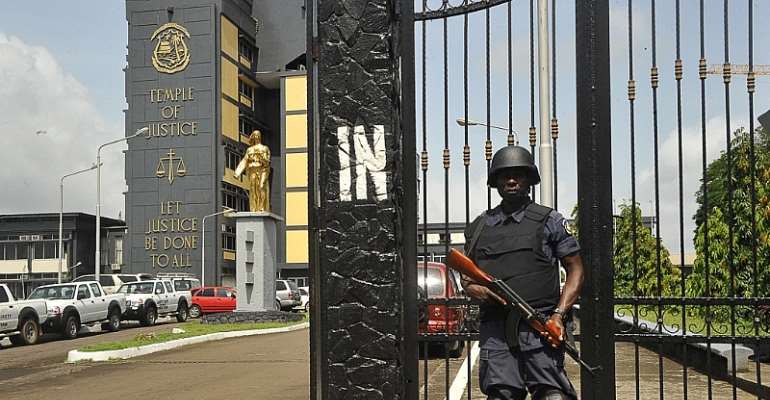 A police officer guards the Supreme Court in Monrovia in November 2017. Judge Blamo Dixon of Criminal Court C in Monrovia ordered the management and entire staff of FrontPageAfrica to appear on June 13, 2023 to defend the outlet's report about alleged bri