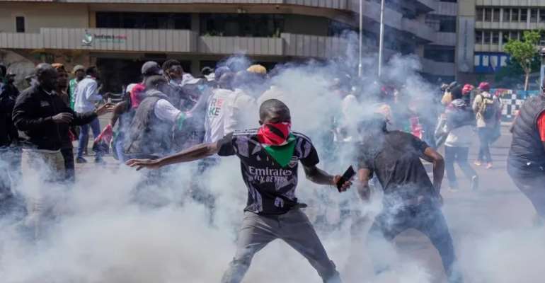 Protesters scatter as police fire teargas at them during a demonstration on the one-year anniversary of deadly anti-tax demonstrations in Nairobi, Kenya, on June 25. Police shut down broadcasts of the protests following a directive from a government agenc