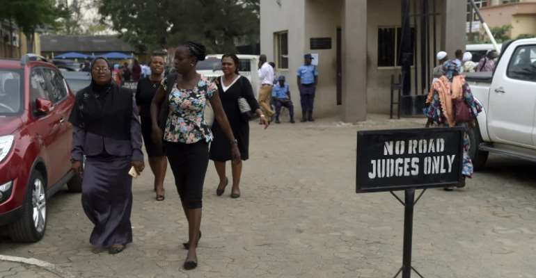 People walk at the premises of Lagos State High Court on January 29, 2019. On June 21, 2022, a federal high court in Ogun state granted bail with strict conditions to Nigerian publisher Olamilekan Hammed Adewale Bashiru. (AFP/Pius Utomi Ekpei)
