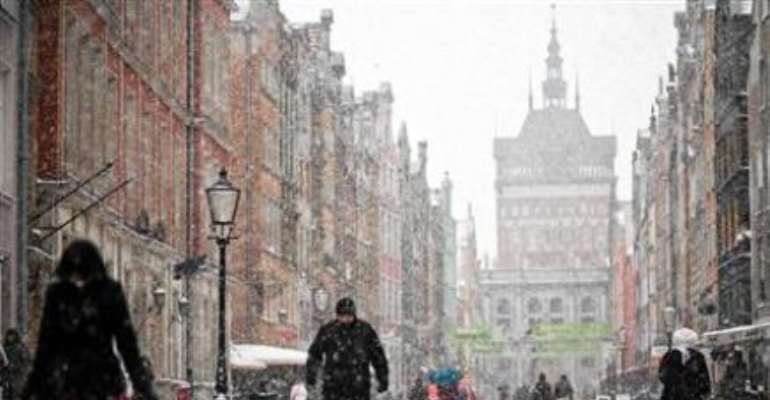 People walk on the main street in the Old Town during heavy snowfall in Gdansk, northern Poland