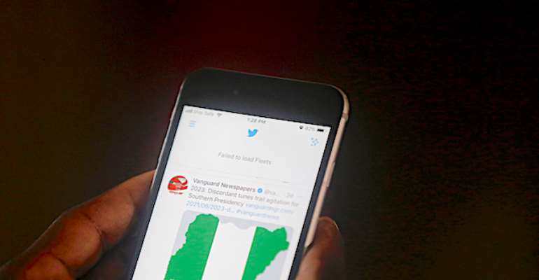 A man uses his mobile phone to read headline news on Twitter in Lagos, Nigeria, on June 7, 2021. Two Nigerian journalists talked to CPJ about the government's ongoing Twitter ban. (AP Photo/Sunday Alamba)