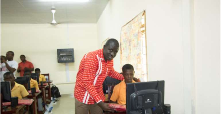 Samuel Gyimah, National Distribution Manager - Airtel Ghana, with a student trying his hands on a computer set in the ICT centre.