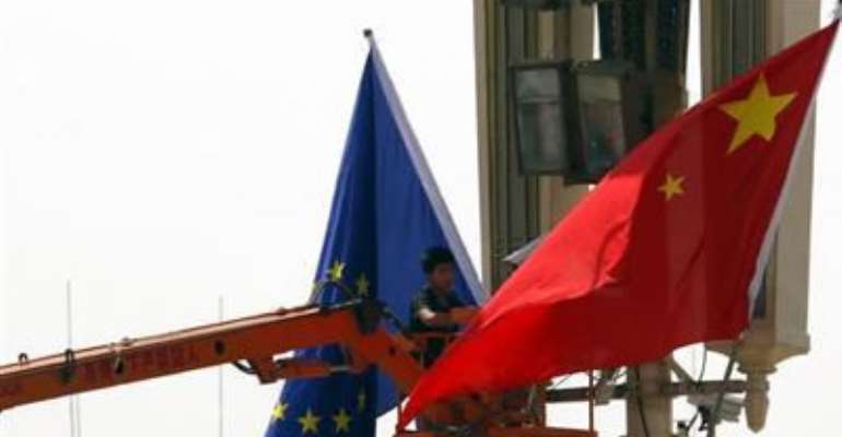 A WORKER ON A CHERRY PICKER HANGS A EUROPEAN UNION FLAG NEXT TO A CHINESE NATIONAL FLAG AT BEIJING'S TIANANMEN SQUAREIN THIS MAY 16, 2011