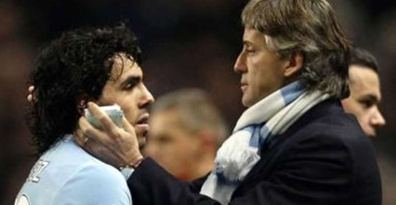 MANCHESTER CITY'S MANAGER ROBERTO MANCINI (R) HUGS CARLOS TEVEZ AFTER THEIR ENGLISH PREMIER LEAGUE SOCCER MATCH AGAINST STOKE CITY AT THE CITY OF MANCHESTER STADIUM IN ENGLAND, DECEMBER 26, 2009.