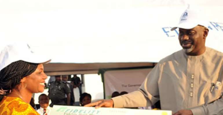 CROSS RIVER STATE GOVERNOR, SENATOR LIYEL IMOKE(R) PRESENTING A CHEGUE TO A FARMER, MRS. PATRICIA UBI DURING THE FLAG OFF OF  N1 BILLION AGRICULTURAL LOAN SCHEME TO ENABLE FARMERS IN UGEP, YAKURR LOCAL   GOVERNMENT AREA.