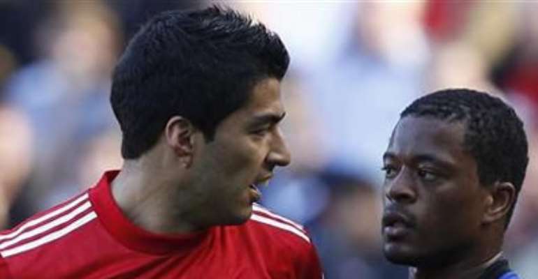 LIVERPOOL'S LUIS SUAREZ (L) AND MANCHESTER UNITED'S PATRICE EVRA EXCHANGE LOOKS DURING THEIR ENGLISH PREMIER LEAGUE MATCH AT ANFIELD, OCTOBER 15, 2011.