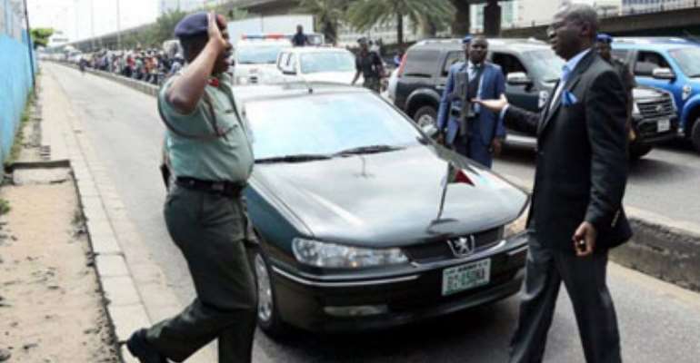 CAUGHT IN THE ACT…Lagos State Governor, Mr. Babatunde Fashola, SAN, (right) asking Colonel K. I. Yusuf why he drove on the BRT lane illegally, when he was apprehended being driven in an Army Green Peugeot 406 with number-plate BO1-150 NA at Outer Marina