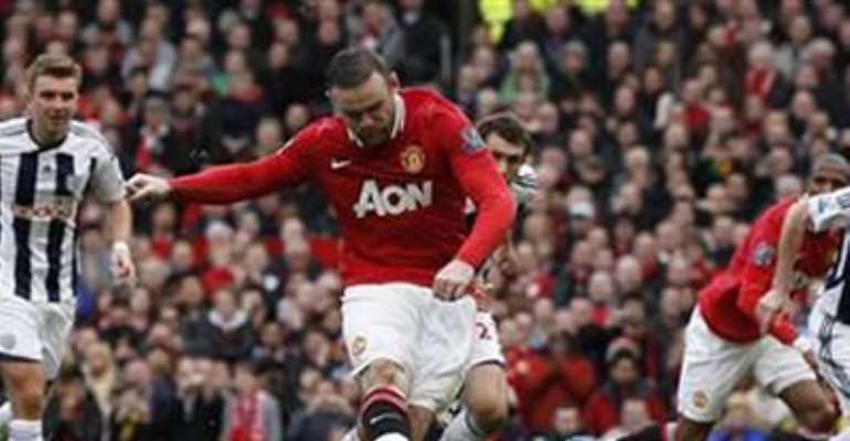 MANCHESTER UNITED'S WAYNE ROONEY SCORES HIS SIDES SECOND GOAL DURING THEIR ENGLISH PREMIER LEAGUE SOCCER MATCH AGAINST WEST BROMWICH ALBION AT OLD TRAFFORD IN MANCHESTER, MARCH 11, 2012.