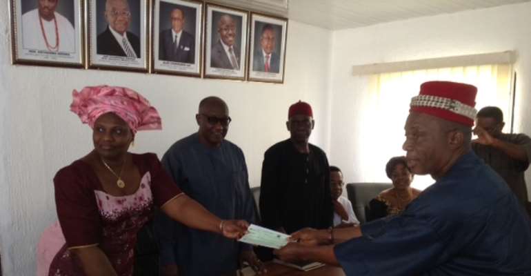 Comissioner of Finance handing a cheque to the Igwe of Ivite Ikem

