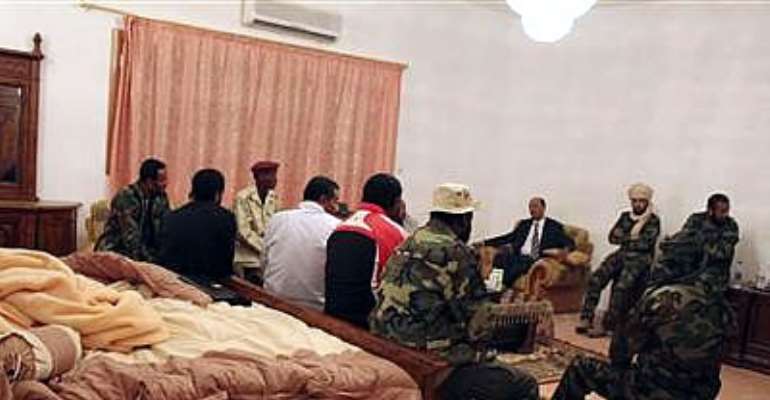 LIBYAN FIGHTERS SPEAK TO A MEMBER OF THE NATIONAL TRANSITIONAL COUNCIL (NTC) IN A ROOM IN MUAMMAR GADDAFI'S VILLA JUST OUTSIDE OBARI NOVEMBER 3, 2011.