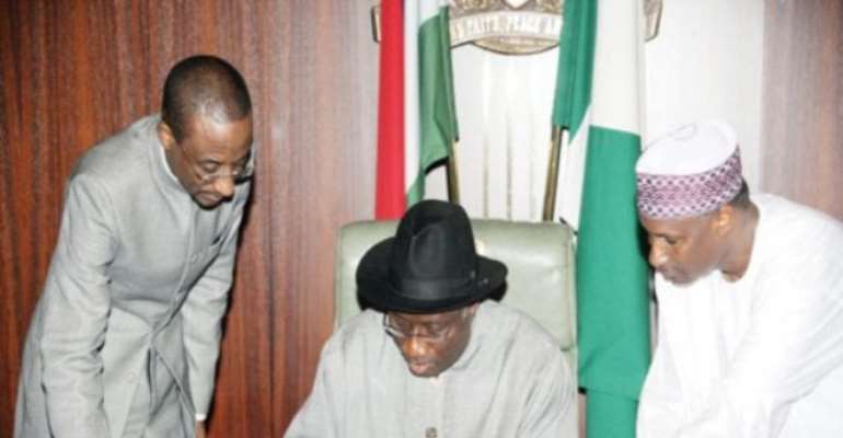 PHOTO: PRESIDENT GOODLUCK JONATHAN SIGNING THE BILL CREATING THE AMCON.