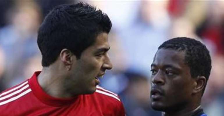 LIVERPOOL'S LUIS SUAREZ (L) LOOKS AT MANCHESTER UNITED'S PATRICE EVRA (R) DURING THEIR ENGLISH PREMIER LEAGUE SOCCER MATCH AT ANFIELD IN LIVERPOOL, NORTHERN ENGLAND OCTOBER 15, 2011.