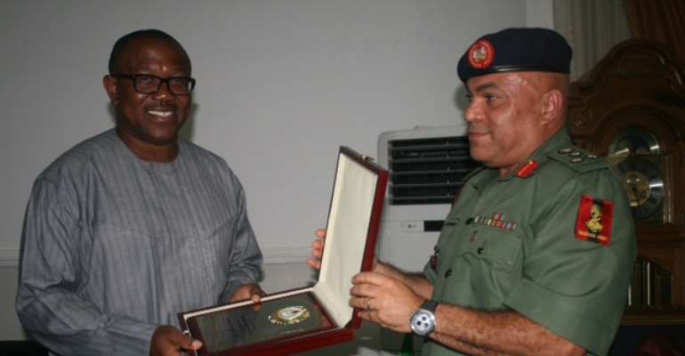 The Director-General of National Youth Service Corps, Brig. Gen. Nnamdi Okorie-Affia (right), making a presentation to Gov. Obi (left), when he paid a visit to the Governor.