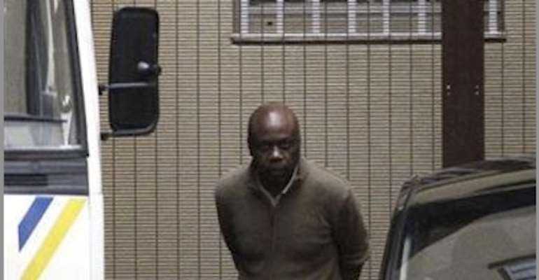 PHOTO: A SENIOR MEMBER OF MEND, HENRY OKAH IN CUFFS, LEAVING A JOHANNESBURG COURT TODAY, OCTOBER 14, 2010. PHOTO: REUTERS/SIPHIWE SIBEKO.