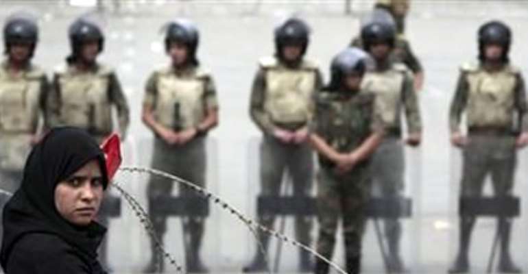 A FEMALE PROTESTER STANDS IN FRONT OF ARMY SOLDIERS AS THEY CLOSE THE ROAD TO ABBASIYA SQUARE NEAR EGYPT'S DEFENCE MINISTRY, IN CAIRO MAY 4, 2012.
