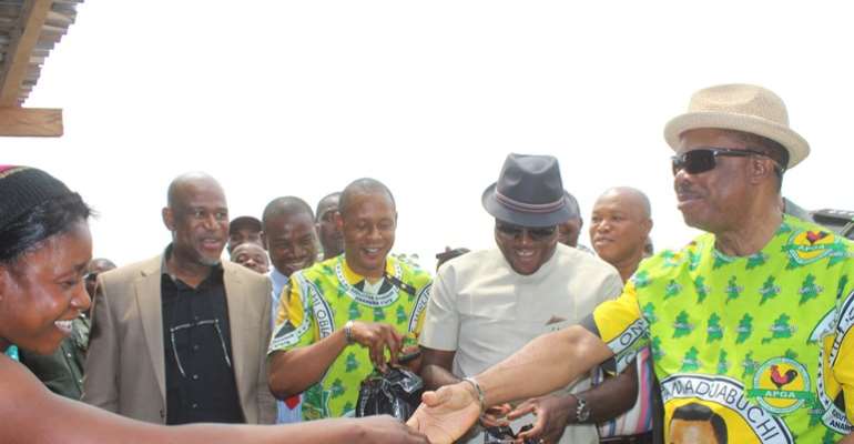Anambra State Governor, Chief Willie Obiano in a handshake with Madam Awele, the dry fish seller across Ezu Bridge in Ayamelum Local Government Area.