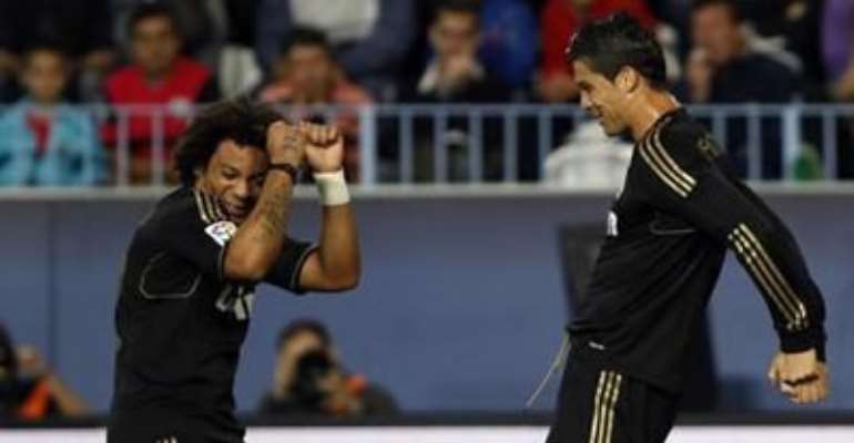 REAL MADRID'S CRISTIANO RONALDO (R) AND MARCELO DANCE AS THEY CELEBRATE AFTER RONALDO'S GOAL AGAINST MALAGA DURING THEIR SPANISH FIRST DIVISION SOCCER MATCH AT LA ROSALEDA STADIUM IN MALAGA OCTOBER 22, 2011.