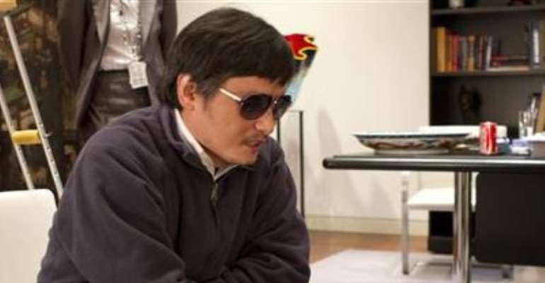 A HANDOUT PHOTO FROM THE U.S. EMBASSY BEIJING PRESS OFFICE SHOWS BLIND ACTIVIST CHEN GUANGCHENG (C) SPEAKING INTO A PHONE IN BEIJING, MAY 2, 2012.