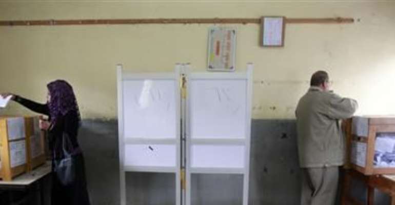 A MAN AND A WOMAN CAST THEIR VOTES IN A SCHOOL USED AS A VOTING CENTER IN AL-ARISH CITY, NORTH SINAI, JANUARY 4, 2012.
