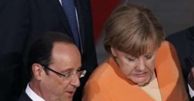GERMAN CHANCELLOR ANGELA MERKEL (C) GRIMACES AS SHE STEPS OFF A STAGE FOLLOWING A FAMILY PHOTO WITH NATO LEADERS INCLUDING FRENCH PRESIDENT FRANCOIS HOLLANDE (L) AT SOLDIER FIELD IN CHICAGO, MAY 20, 2012.
