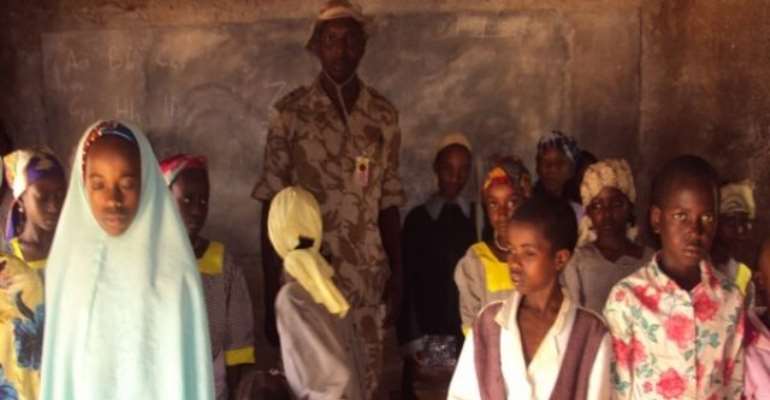 PHOTO: A NIGERIAN SOLDIER IN CLASS WITH FULANI PUPILS IN THE BARKIN LADI LOCAL GOVERNMENT AREA OF PLAEAU STATE.