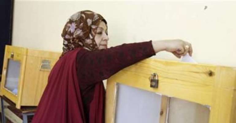 A WOMAN CASTS HER VOTE FOR THE PARLIAMENTARY ELECTION IN CAIRO, NOVEMBER 28, 2010.