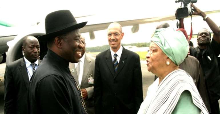 PRESIDENT GOODLUCK EBELE JONATHAN IS GREETED BY LIBERIAN PRESIDENT ELLEN JOHNSON SIRLEAF ON ARRIVAL IN MONROVIA.