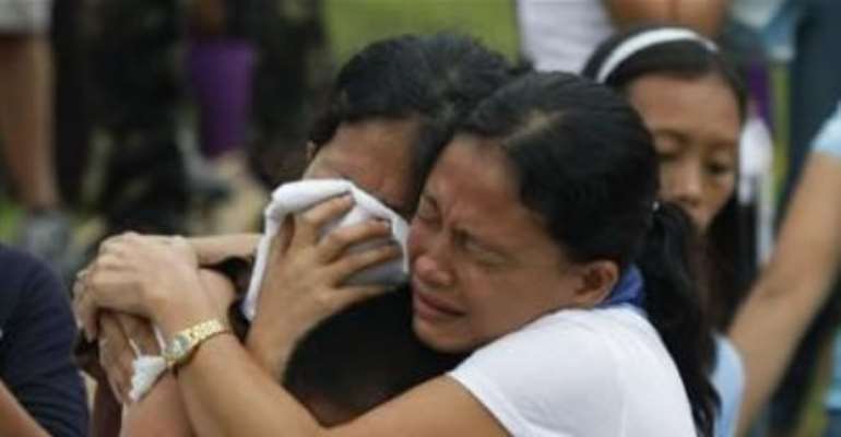 RELATIVES MOURN DURING A MASS BURIAL FOR TYPHOON WASHI VICTIMS IN A CEMETERY IN ILIGAN CITY, SOUTHERN PHILIPPINES DECEMBER 20, 2011.