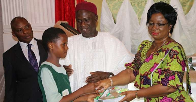 Senior Special Assistant To The President On MDGs Presenting Copies Of The Free 3 Million MDGs Branded Exercise Books To The One Of The Benefiting Pupils In Abuja On Tuesday