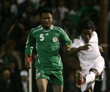 Ghana's Laryea Kingson, right, strikes the ball as Nigeria's Jon Obi Mikel, left, standing looking, during their International friendly soccer match at Griffin Park Stadium, London, Tuesday Feb. 6, 2007. (AP Photo/Graham Hughes )