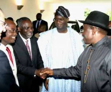 President Jonathan shaking hands with Prof. Bart Nnaji, Special Adviser to the President on Power, while Gov. Babatunde Fashola of Lagos and others look on.