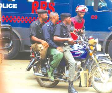 LAWBREAKERS: Three policemen on a motorbike without wearing crash helmets. Photo: Olatunji Obasa