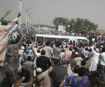 PEOPLE CHASING AFTER BUHARI''S BUS
