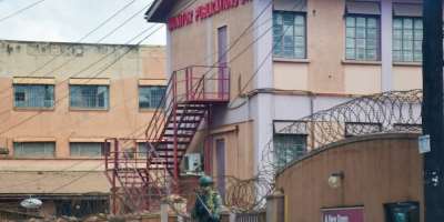 A member of Uganda People's Defence Forces stands at the headquarters of Nation Media Group-Uganda, a building in Kampala, Uganda that houses the Daily Monitor and radio broadcasters KFM and Dembe FM,